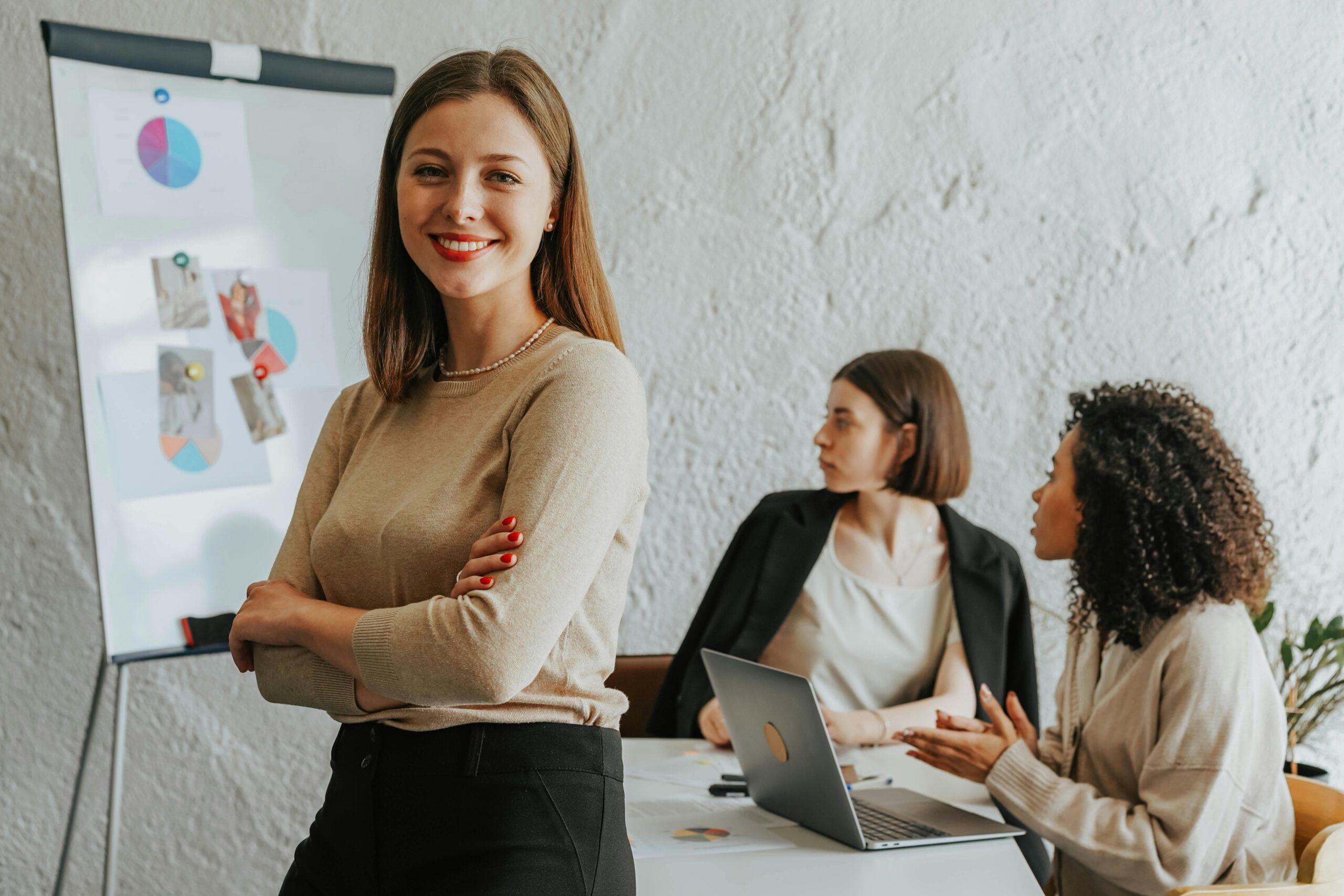 Sales rep smiling while a team holds a presentation on a whiteboard